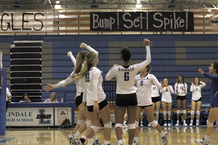 The Lady Eagles volleyball team celebrates mid-game. The team was crowned district champion but lost in playoffs.