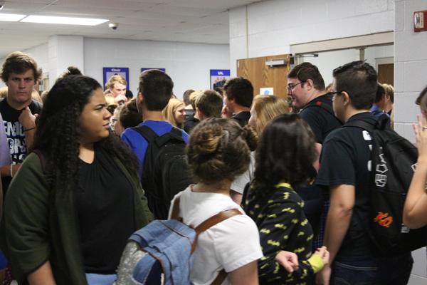 Groups of students walk through the hall on their way to class/