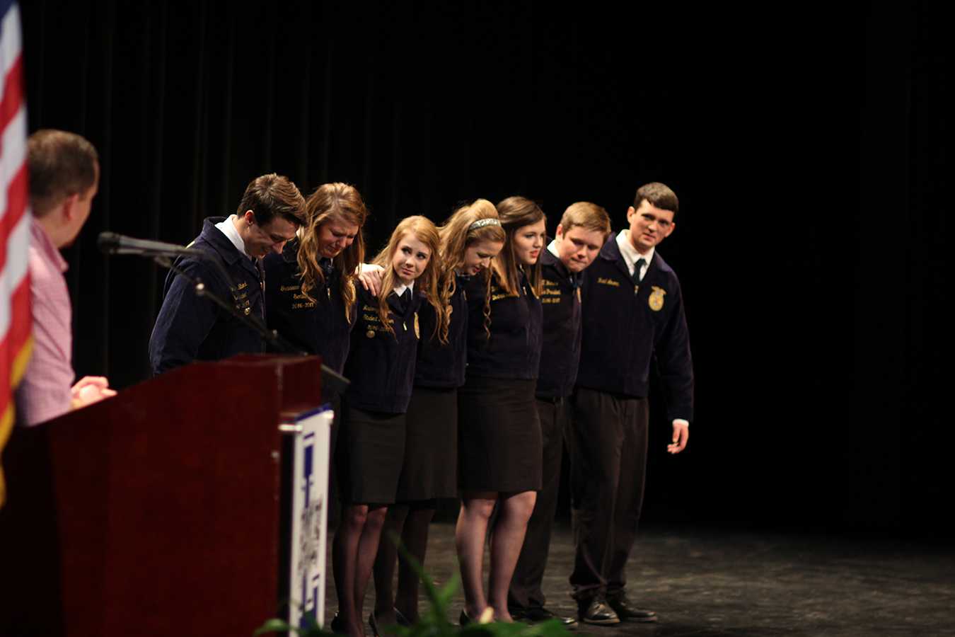 FFA Students gather on stage in a moment of shared emotion. 
