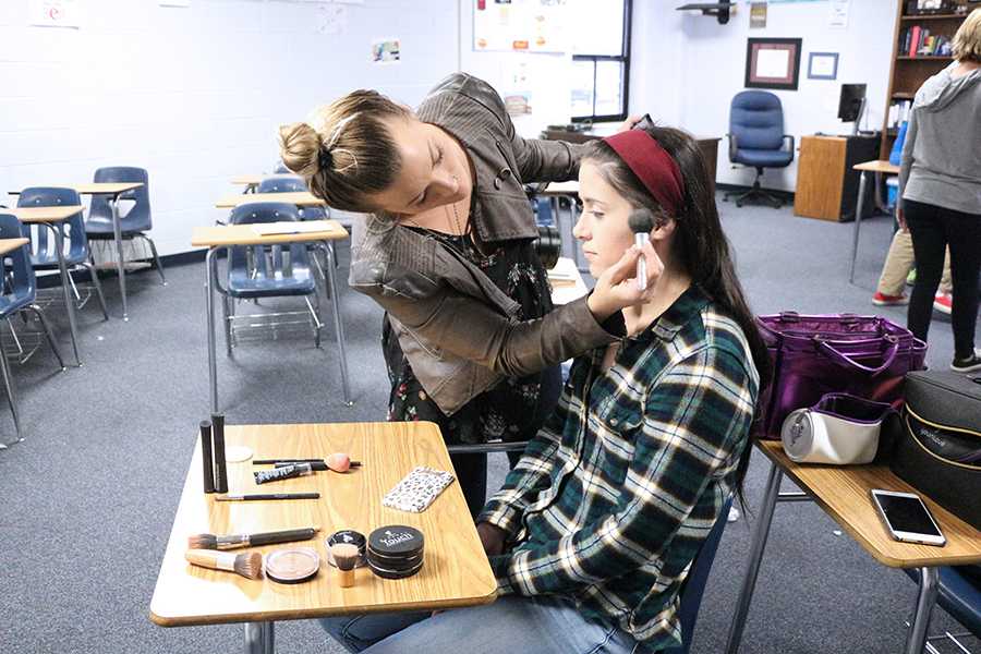 Senior and amateur MMA fighter Taylor Pace has makeup applied before a scene.