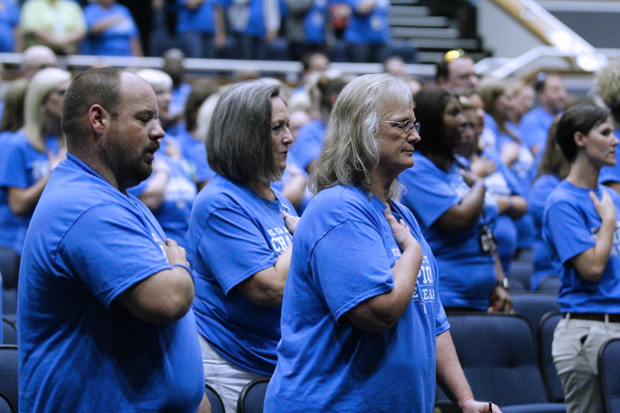 Staff members stand to recite the pledges. The pledges were led by student council member Logan Hale.