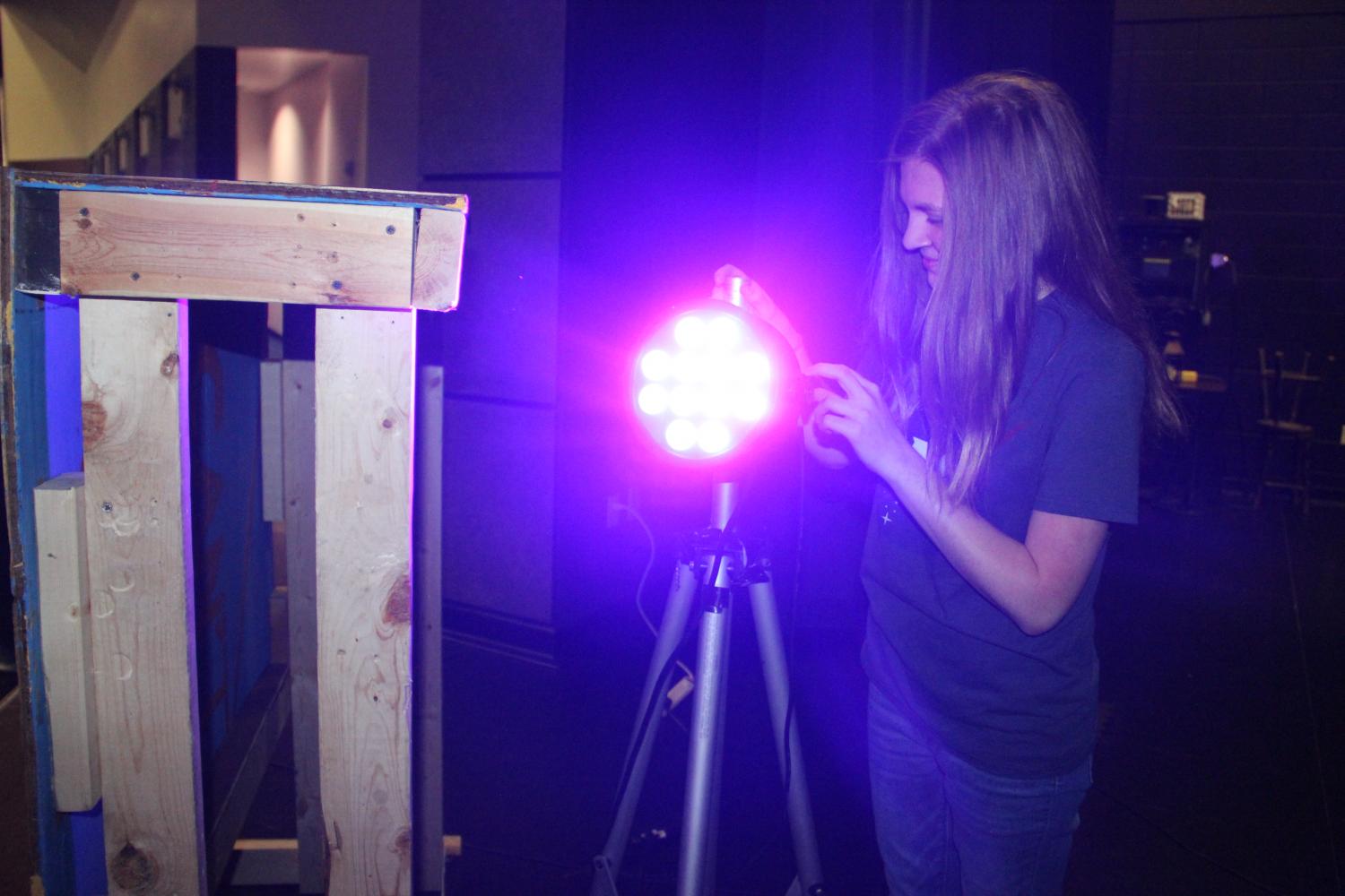 Sophomore Jamie Thornton adjusts a light on set. The theater department is currently working on Shakespeares Midsummer Nights Dream.