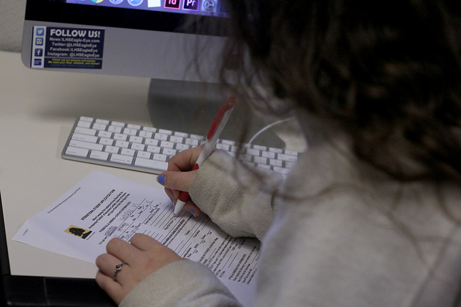 Student fills out college application. Many colleges have early application due soon.