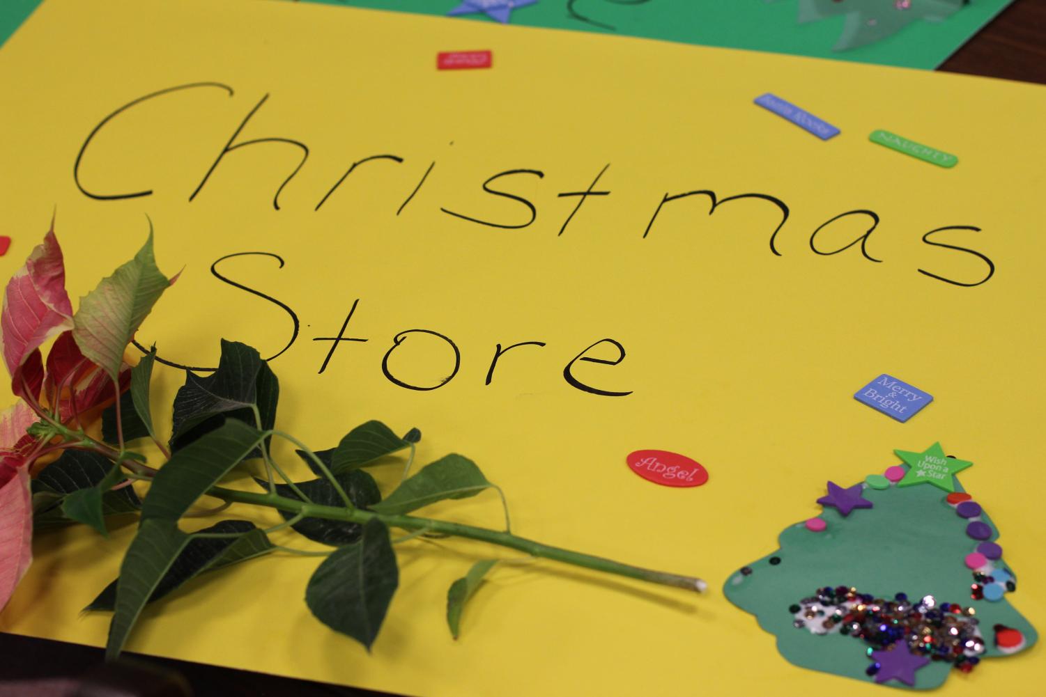 A poinsettia rests on an official store sign. The Life Skills students and sponsors opened a Holiday Store in the school library.
