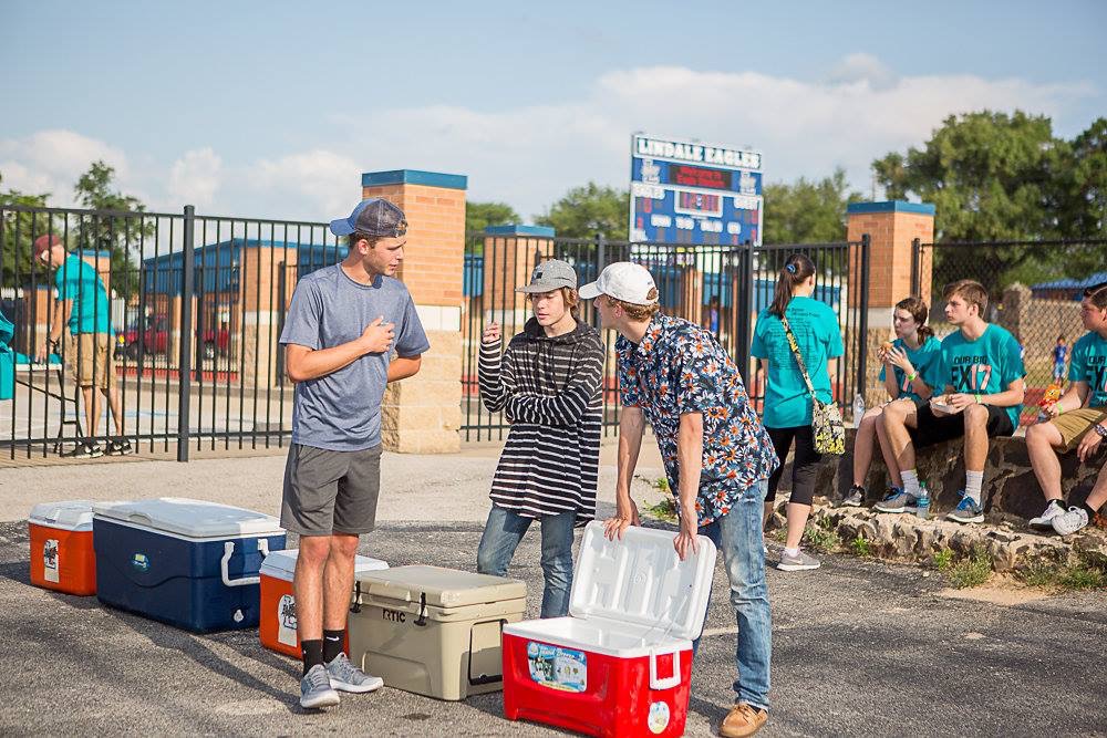 Three current seniors chat around a cooler at an LHS Project Graduation fundraiser at the end of the 2016-2017 school year. Several events and other fundraisers have been hosted to finance the senior trip and breakfast at the end of the year. 