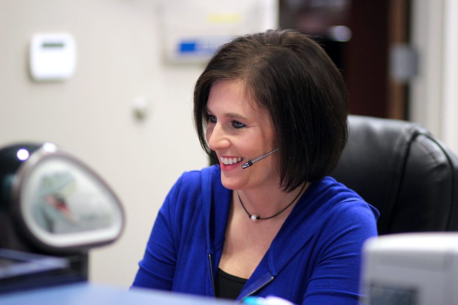 Office secretary Regina Hicks takes a phone call. Hicks is known as the face of the office because her charming smile is the first you see when you walk in.
