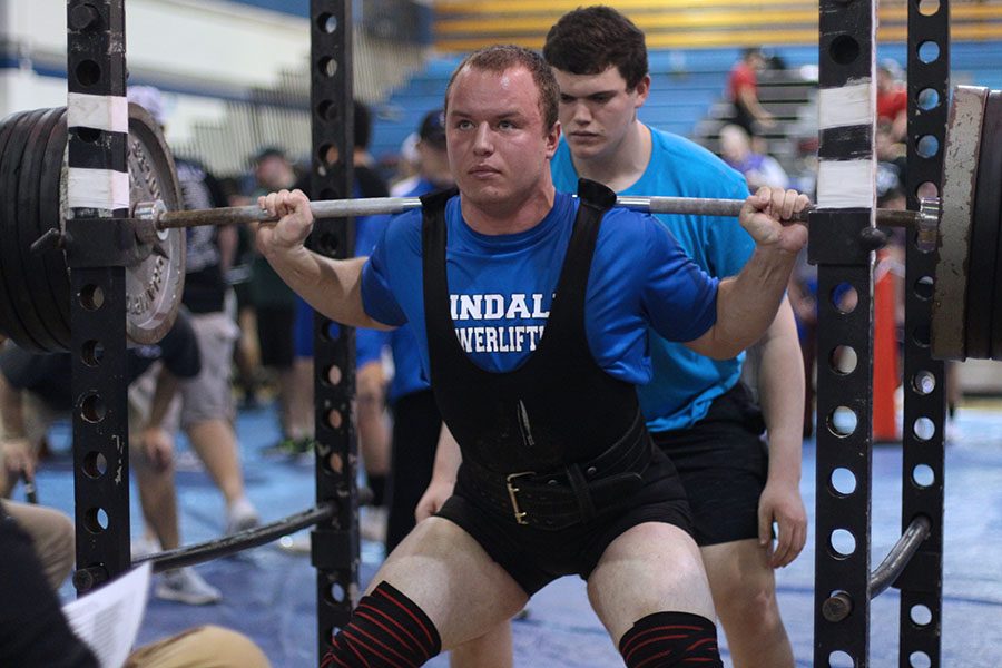 Senior Ty McDaniel squats at the regional powerlifting meet. McDaniel won the overall award for best squat.