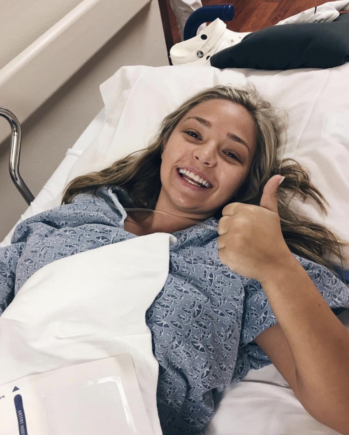Ally Perkins holds a thumb up after her appendix surgery. She stays postivie through prayer and worship during her hospital visits.