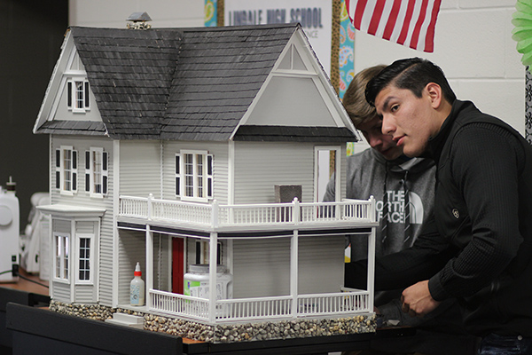 Junior Santiago Castillo puts finishing touches on his groups model house. Four houses were built with real-life design elements.