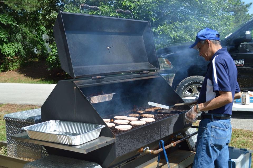 The late Jesse Rodriquez grills burgers before a tailgate party. His family will honor his legacy at the first home football game of the season. 