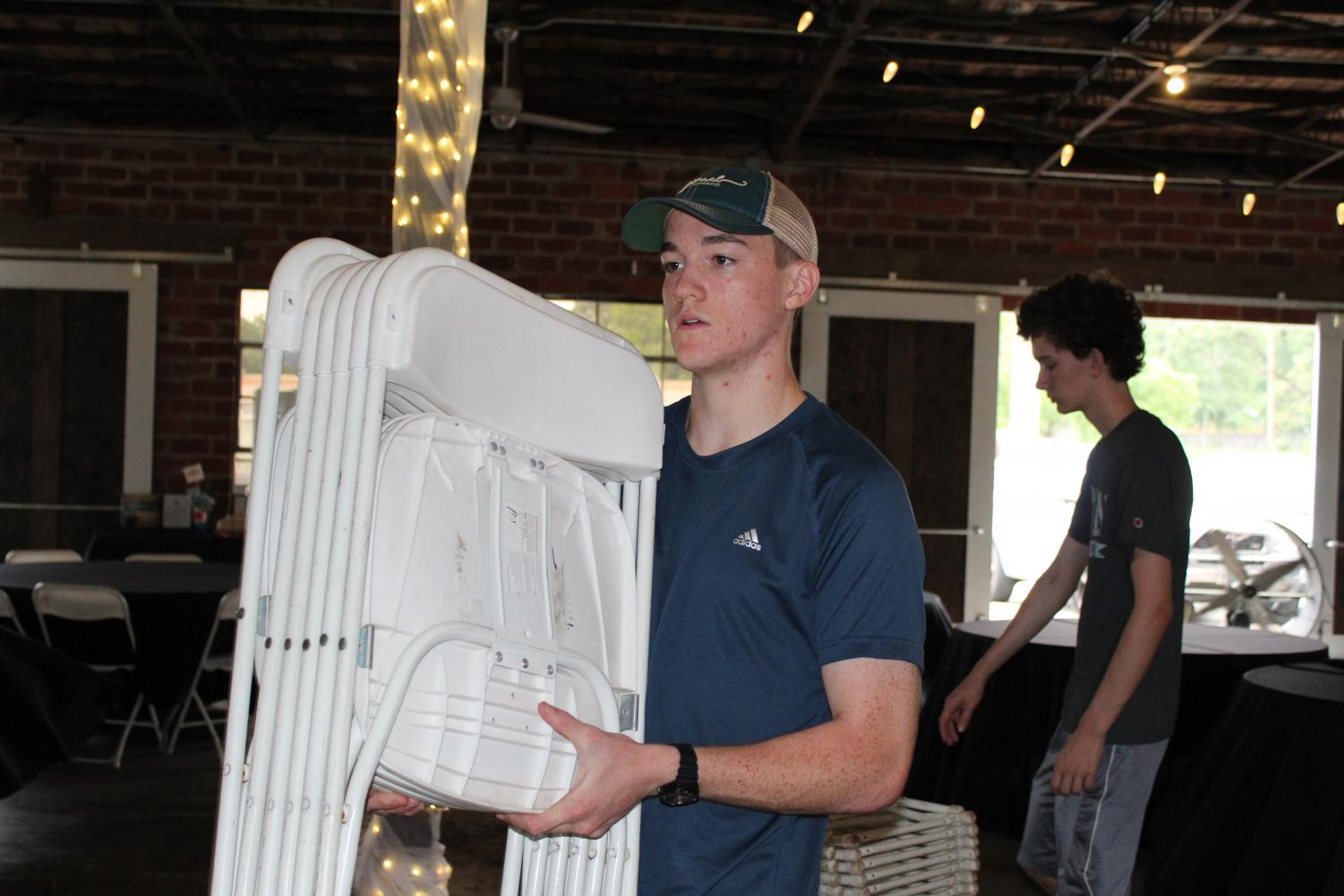Junior Travis Reeves helps at the gala. He set up tables and chairs for the event.
