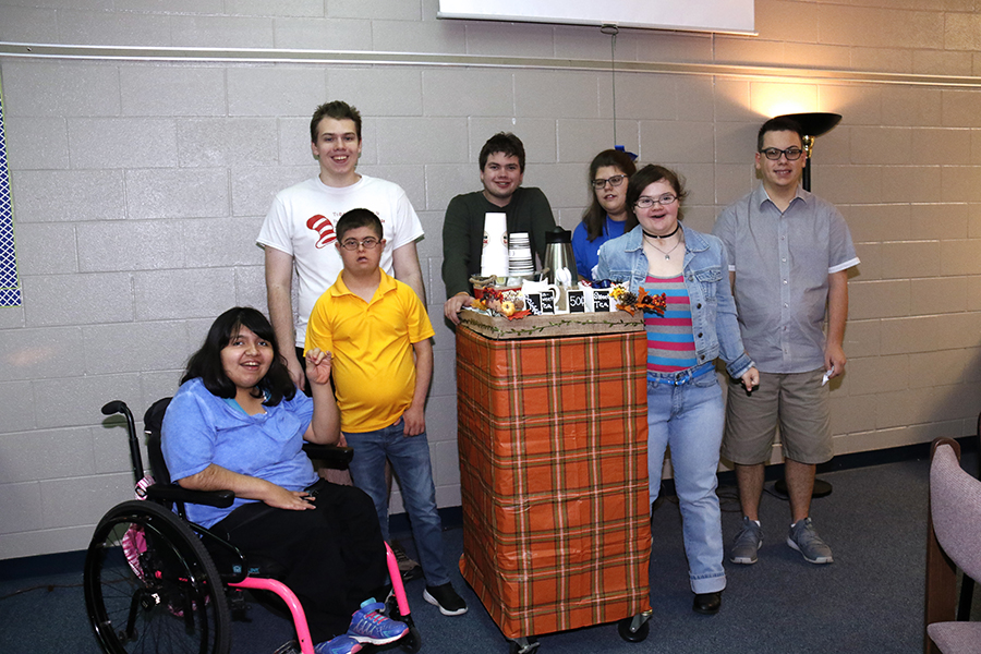 CBI students pose in front of their tea and coffee cart. They decorated it in celebration of fall. 