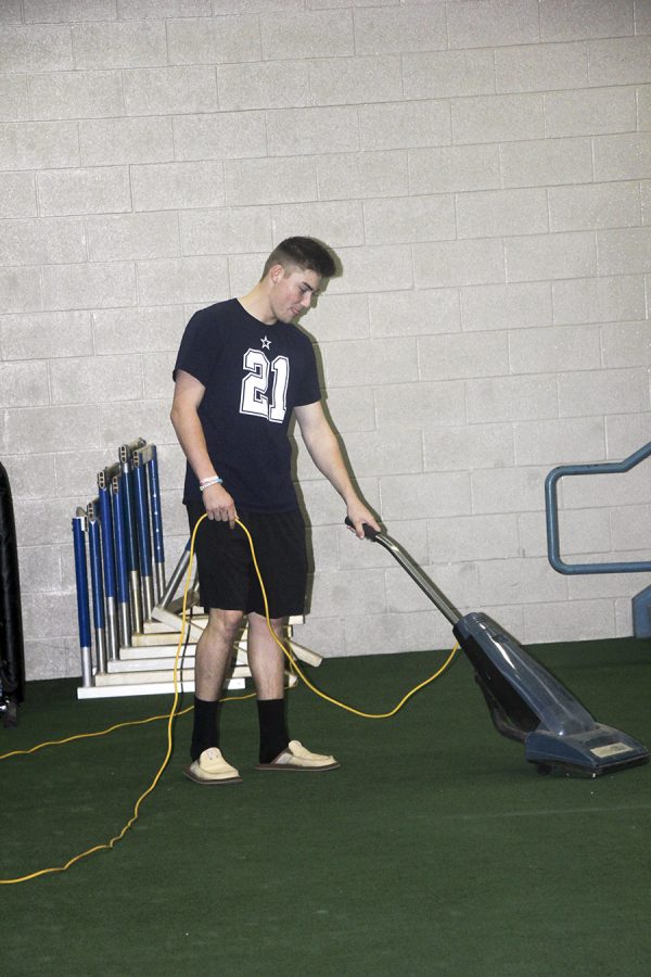 Senior Chase Rozell vacuums the gym. He participates every week in Give Back Days.