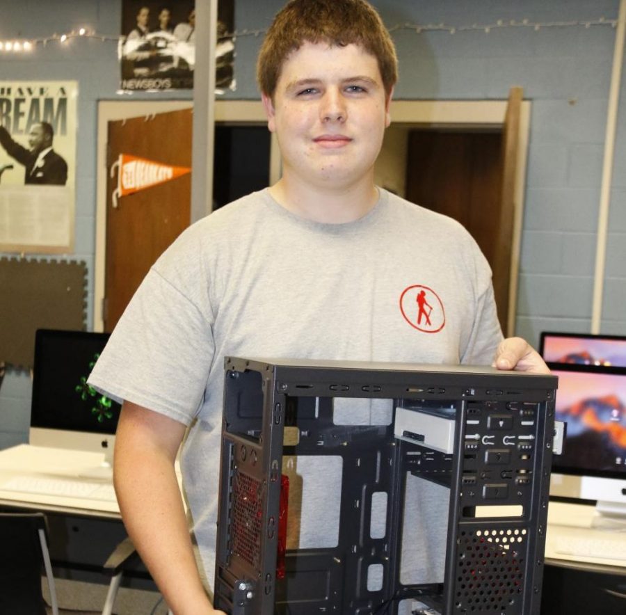 Joshua Doyle holds his computer with the 3D printed part inside. 