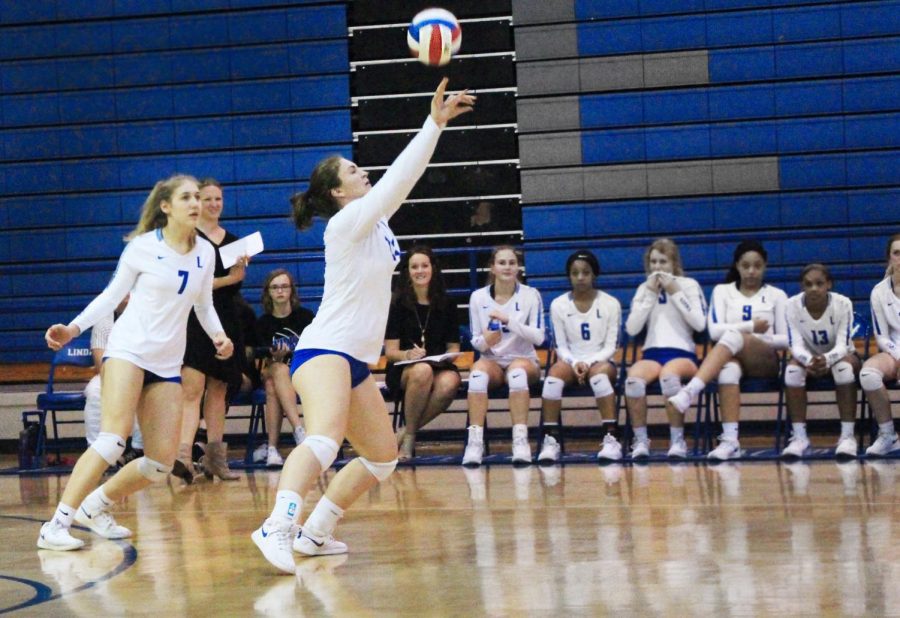 Senior Hannah Knox sets the ball toward the net, where several of her teammates await the ball to spike it over the net in hopes of scoring. They beat Van in four sets in a non-district game.