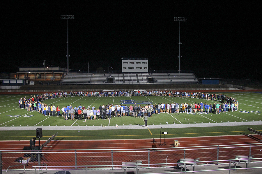 Students gather in a prayer circle in the middle of the football field. FCA promotes Fields of Faith every year.