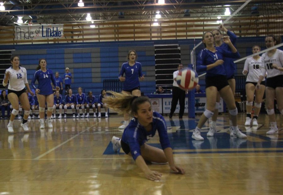 Junior Harleigh Thurman dives to save the quickly falling volleyball and keep it in play. The varsity team beat Royce City in three sets, although both the freshmen and JV teams lost.