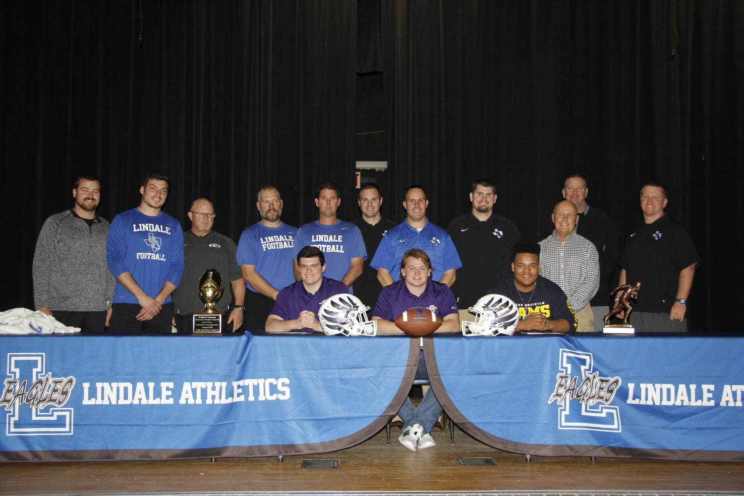 Senior football athletes James Sandifer, Dillon Heinaman and Cason Cheney pose with their coaches at the signing ceremony. Heinaman and Sandifer will be attending Hardin-Simmons University in Abilene, while Cheney will be going to Texas Wesleyan University in Fort Worth.