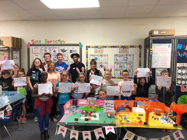 3rd grade students pose with their awards and high school mentors. Each team received an award based on creativity, programming difficulty and unique ideas.  