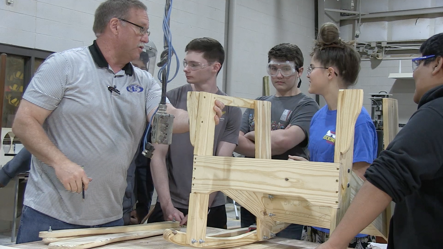Coach John Phillips gives guidance to his students to help them build their chair. He started building them 14 years ago.