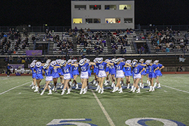 The drill team performs their kick routine at a Friday night game. The new team will begin preparing this summer for the school year. 