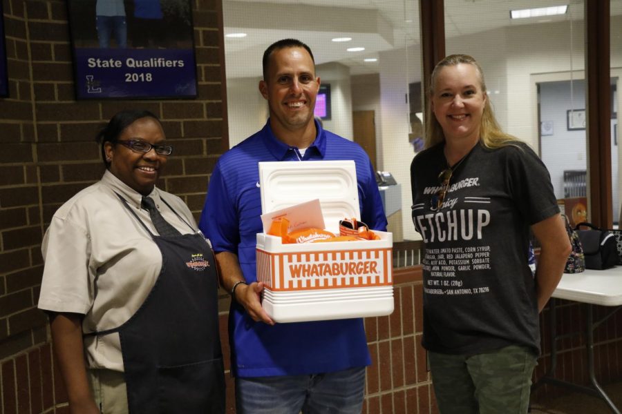 Head football coach Chris Cochran poses with two Whataburger representatives. They presented him with a gift for his nomination as the potential Coach of the Week.
