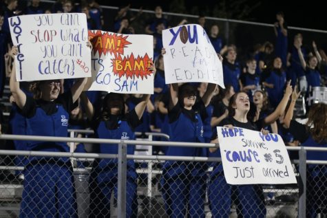 Band Members Make Signs for Football Players