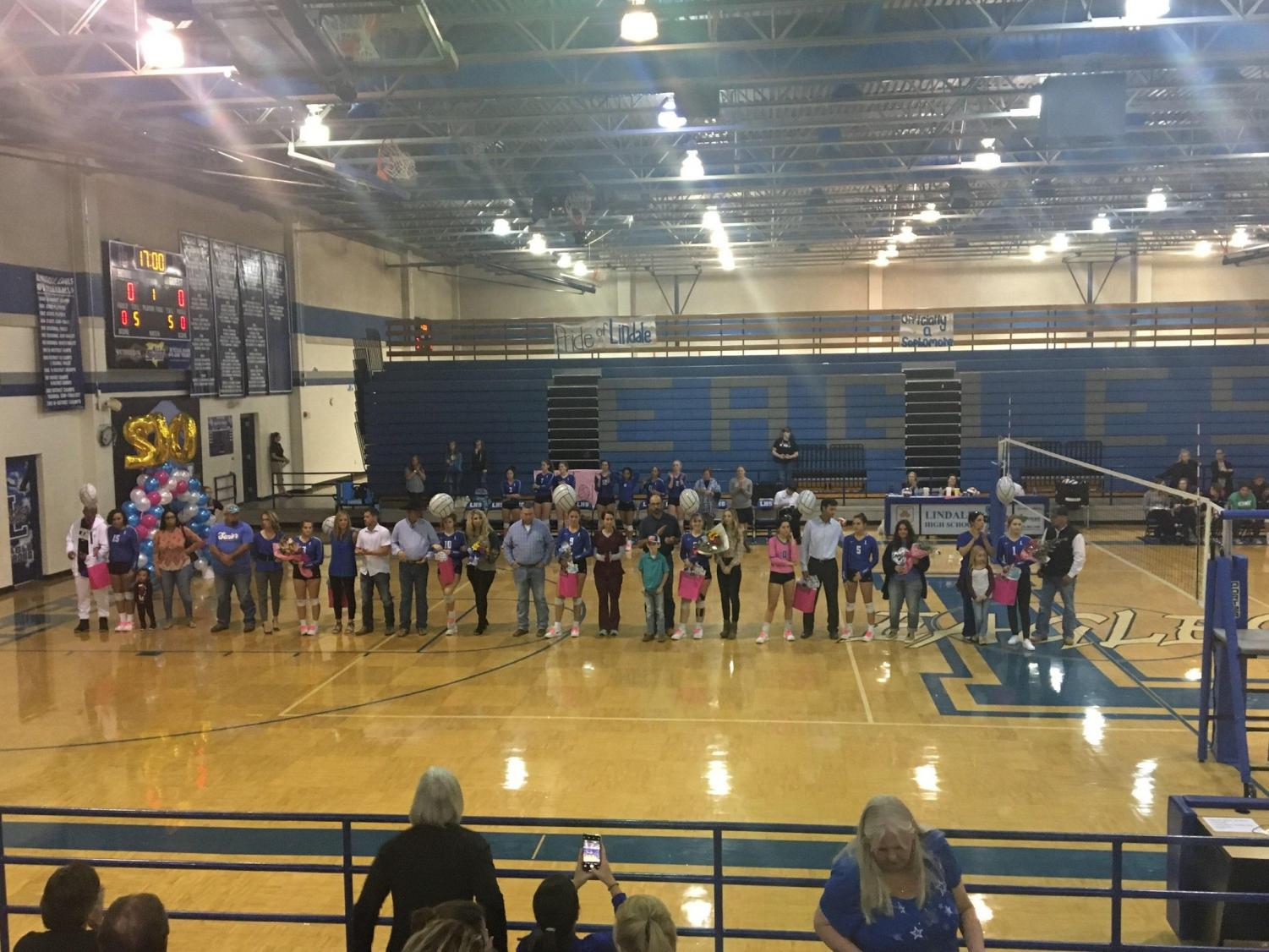 The volleyball seniors stand with their families before the senior night game. The team won the game over Royse City in four sets.