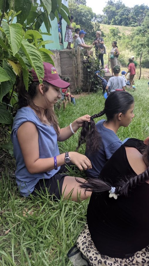 Freshman Christiana Ussery braids a girl’s hair after service. This was in a rural part of Honduras.
