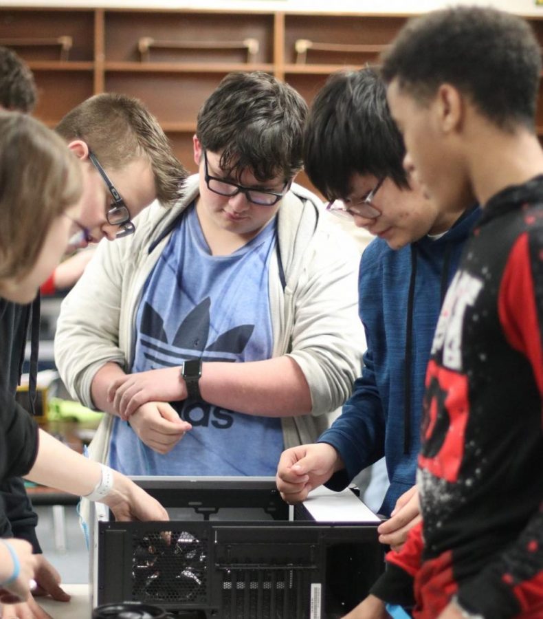 Students in computer maintenance open the side panel to prepare inserting the CPU and Motherboard in the case. This is the first year for the computer maintenance class.