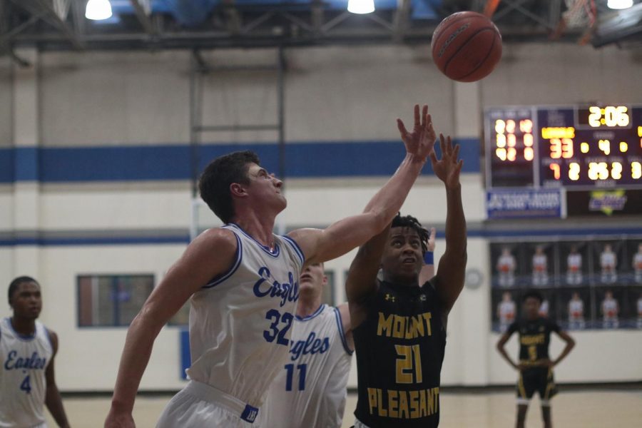 Senior Jacob Koeshall blocks a shot from a Mt. Pleasant player. The varsity boys' basketball team will play Nacogdoches in the bi-district round of the playoffs Tuesday.