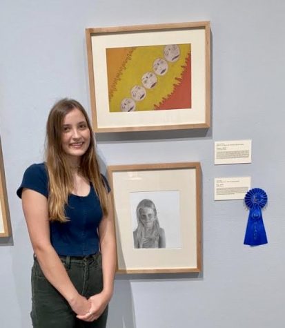 Junior Carlin Root poses next to her a graphite portrait of a young lady named Evy. Root won the the Tyler Museum of Art Annual Senior Exhibition as a junior