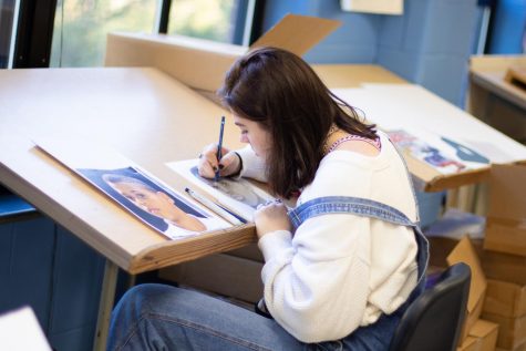 Senior Alli Somes touches up on the details for her portrait.