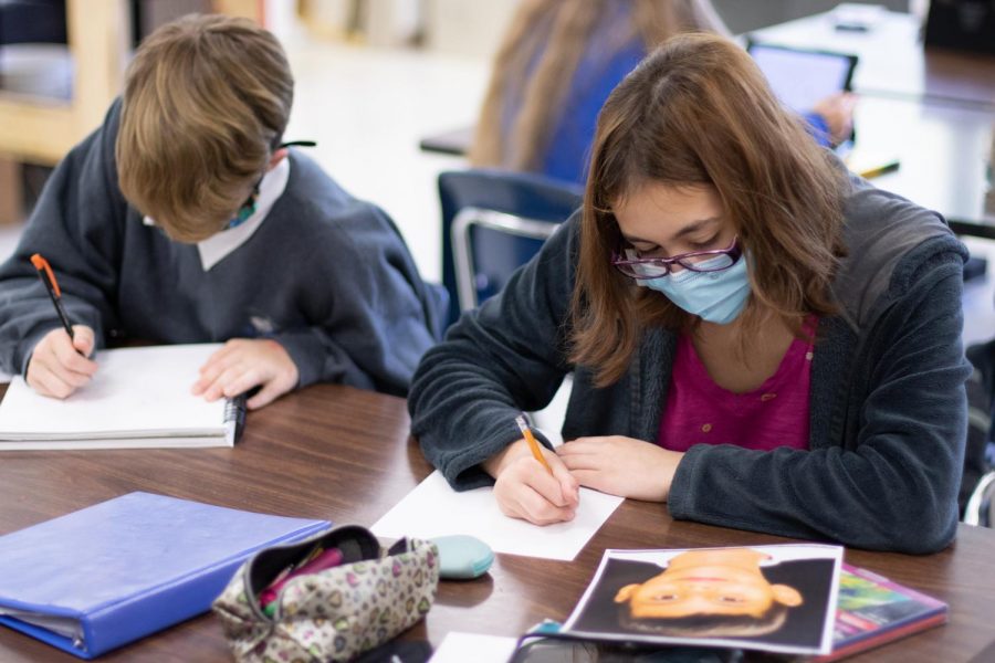 Freshmen Payton Speerly and Julia Montgomery begin working on their portraits while looking at the photograph given to them. Before I even started drawing sketches, I read a 24 page drawing tutorial all about portraits, Montgomery said. Now, I’m about to start working on the final copy.