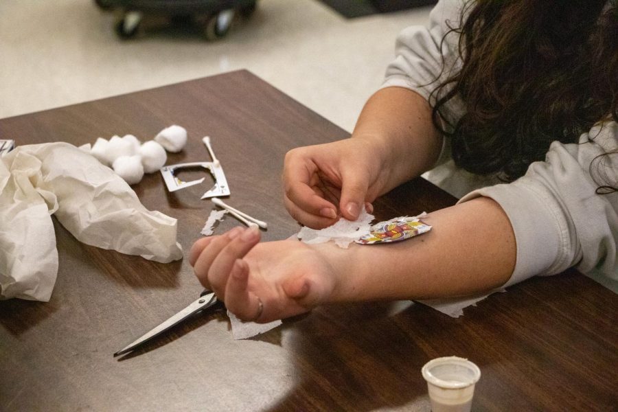 A student applies a fake wound. The fake wounds are made using makeup and different mixtures to make fake skin.