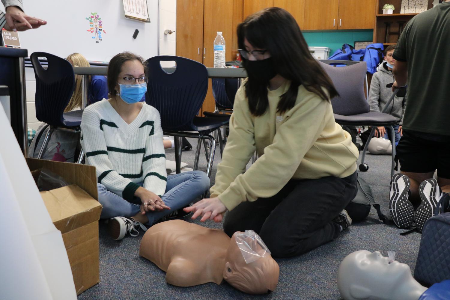 Sophomore Kylie Hester practices CPR on the CPR dummy.