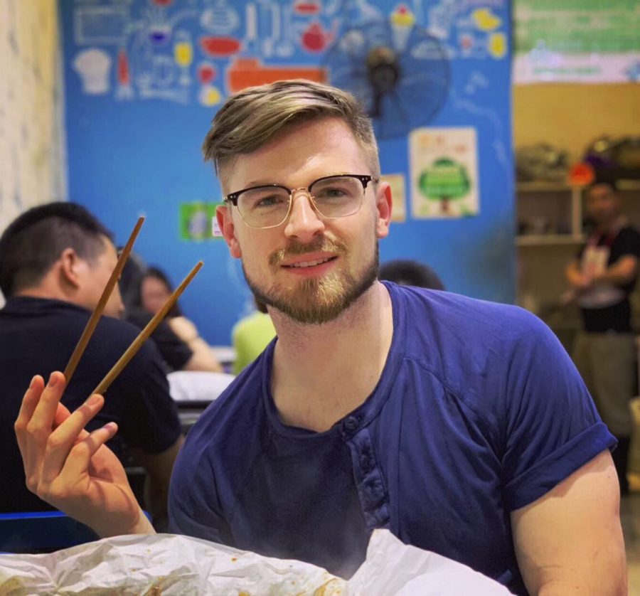 Clemmons poses with chopsticks while eating paper fish at his favorite restaurant in Yibin, China. The fish are caught are caught a mile away in the Yangtze River.