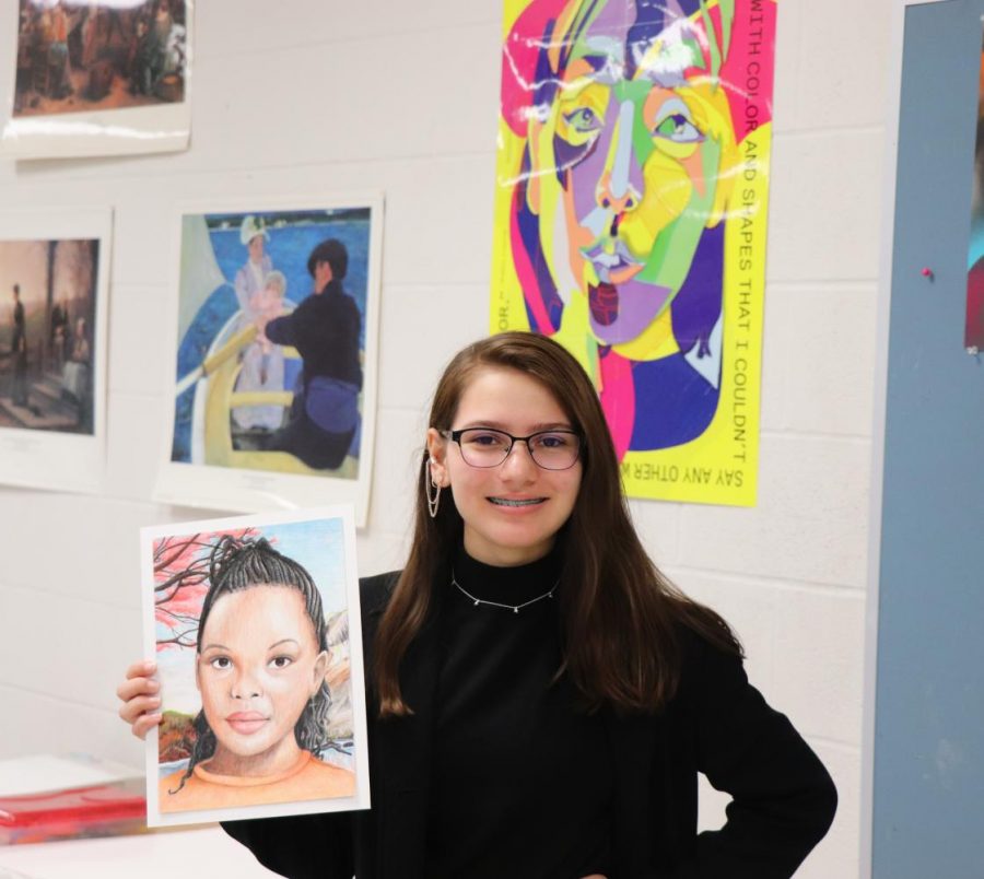 Junior Alisa Thane poses with her drawing from past years project.