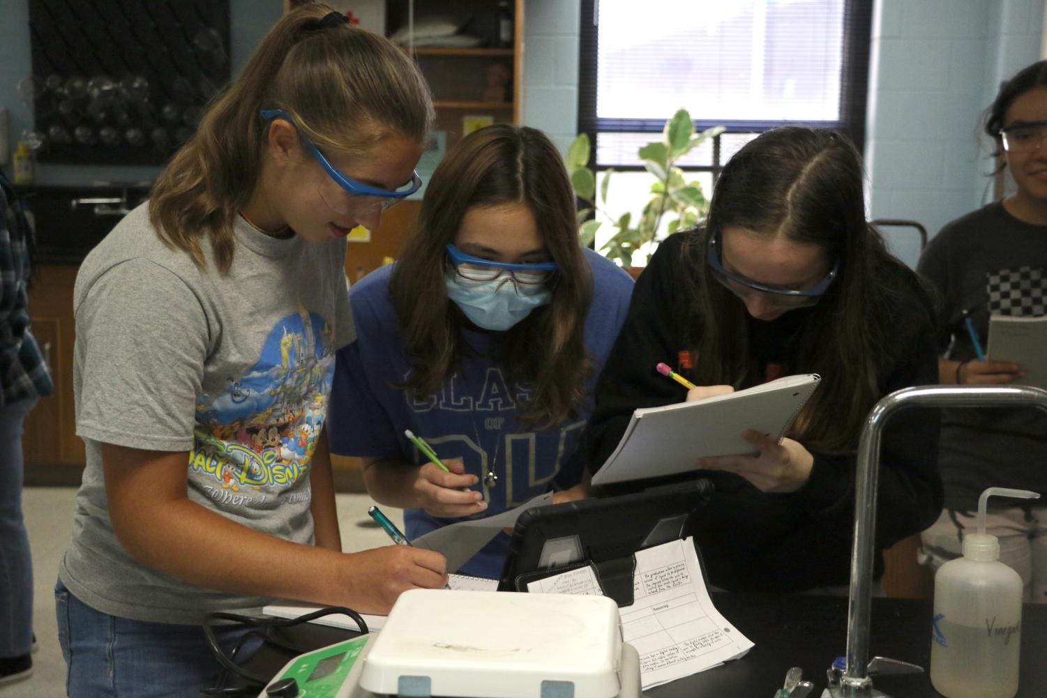 Sophomores Nicole Hines, Julia Montgomery, Alyssa Starkey work on a chemistry lab. Chemistry is a fun class, Hines said. I love doing labs.