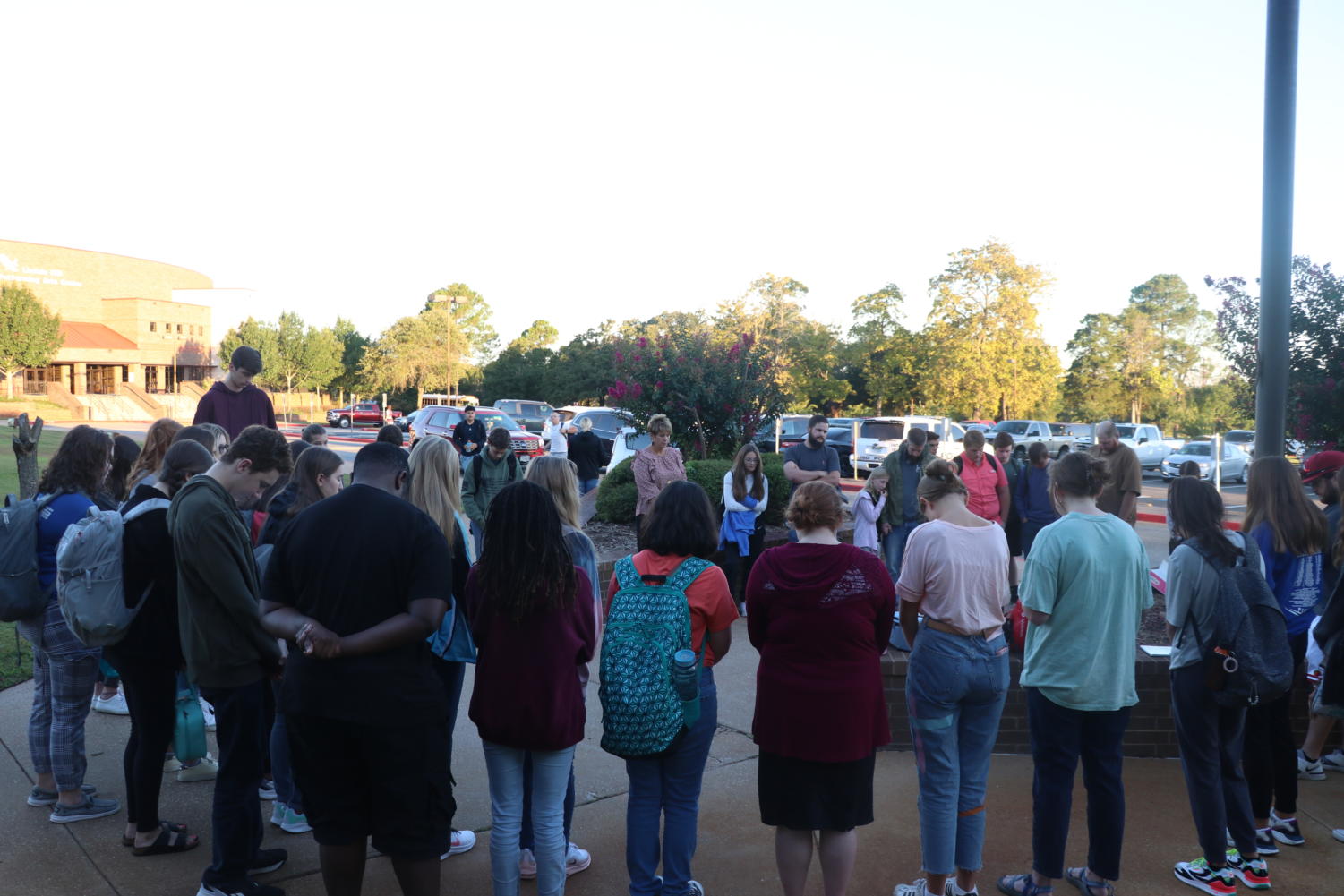 Students gather around the flag pole to pray for the community.