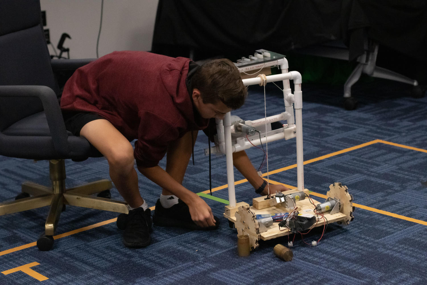 Freshman Isaiah Yard removes the weights from the robot to test the wheels.