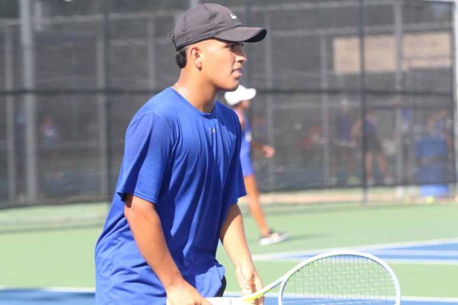Sophomore Emilio Rodriguez playing tennis.