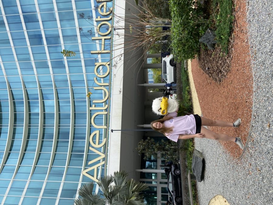 Warrington poses in front of her hotel holding her mascot head.