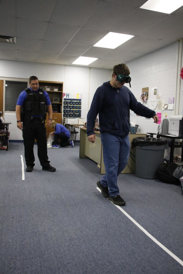 Officer+Dewolfe+allows+students+to+test+impairment+goggles.