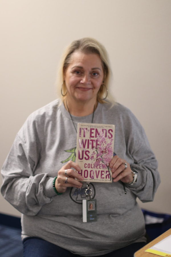 Staff member Debbie Barnett holds up Colleen Hoover's it Ends With Us. She was substituting for Mr. McKenzie's class.