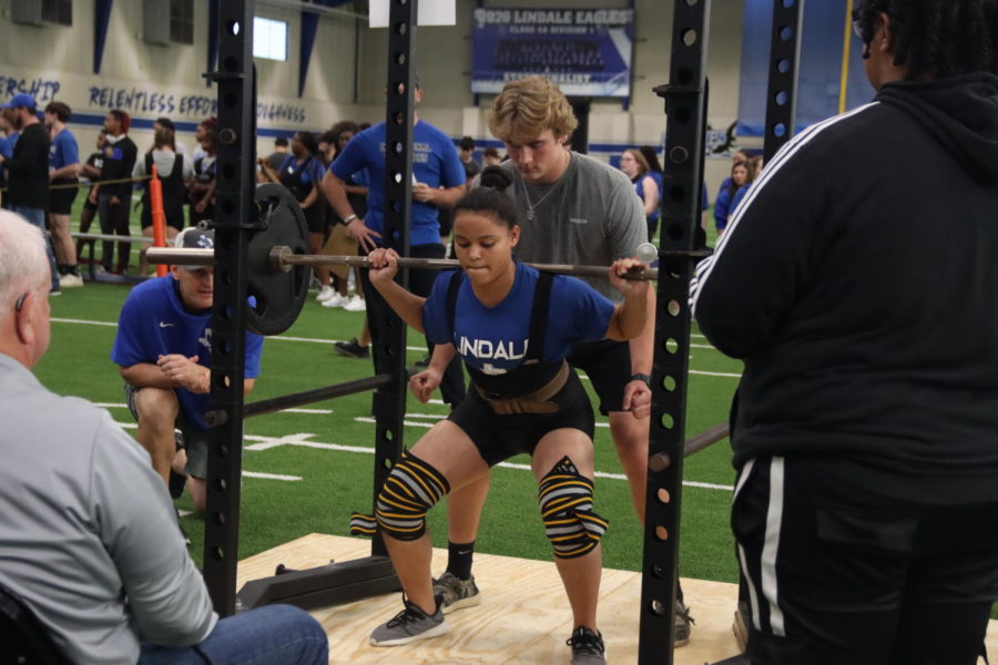 Sophomore Tianna Cooper squats during the powerlifting meet. The girls placed first with 43 points.