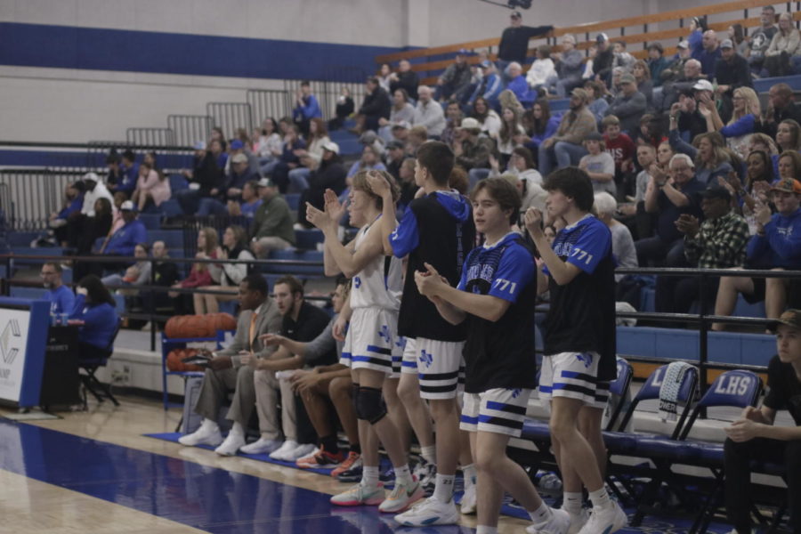 The basketball team cheers on players as they score goals.