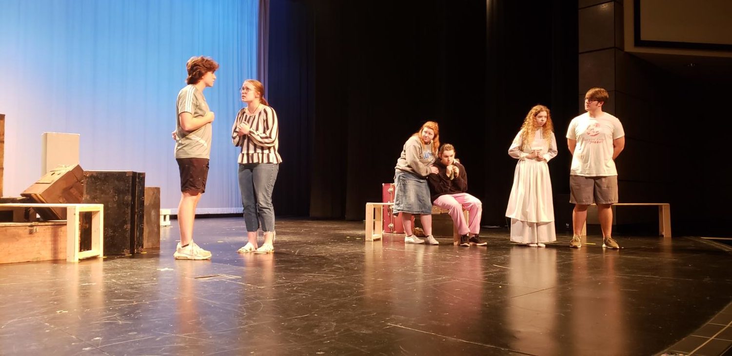 Senior Olivia Harwell and her cast mates practice on the stage. “I enjoy theater for so many things, Harwell said. I love the camaraderie of the cast and the family. We have the ability to love each other.
