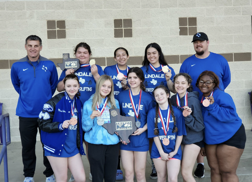The girls powerlifting team poses after competing at regionals. State will be held on March 17.