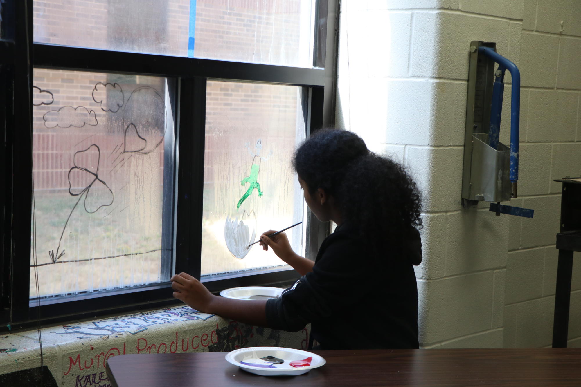 Junior Keyara Jenkins paints window for art mural. 